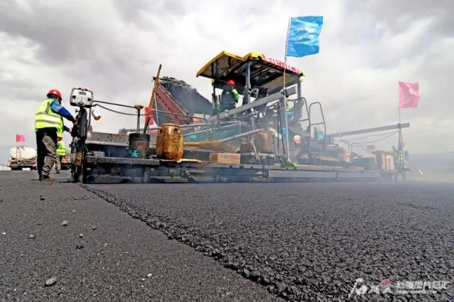 工人在京新高速梧桐大泉至木垒段摊铺沥青。石榴云/新疆日报记者蔡增乐摄