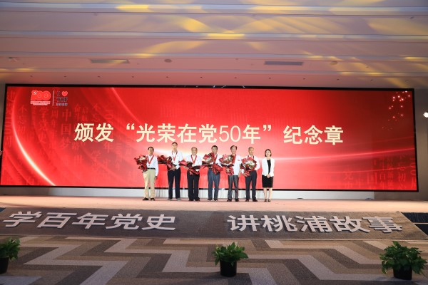 图说：向桃浦老党员代表颁发“光荣在党50年”纪念章