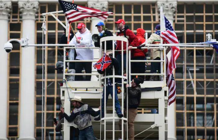 ↑暴乱当天，人们爬上为拜登就职典礼搭建的脚手架。