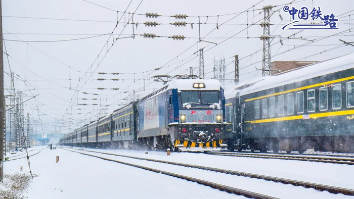 旅客列车带着雪花驶出怀化站。陈泉任 摄