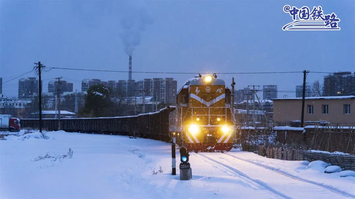 夜幕降临，大雪纷飞，煤炭专列缓缓驶入热电厂，为千家万户送去温暖与光明。傅远翔 摄