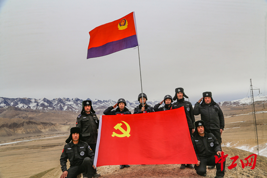 图为巡护后，队员在海拔4100米的古道顶端与党旗警旗合影留念，向警旗致敬，迎接中国人民警察节