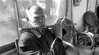     韩新高在吹笛子。