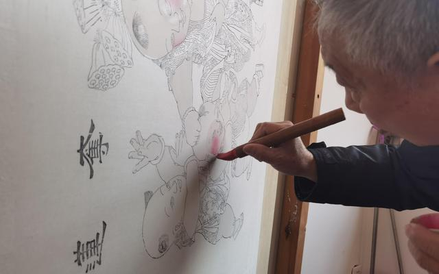 霍庆顺给年画娃娃的脸蛋儿上色。新京报记者 曹晶瑞 摄