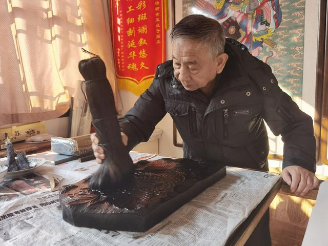 霍庆顺拿着棕榈刷制作年画。新京报记者 曹晶瑞 摄