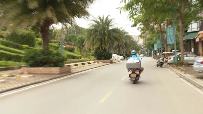 配送路上的王科伟。廖显春 摄