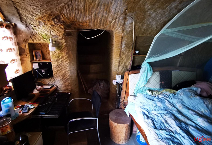  ▲邱中虎的石屋内摆放着床、电脑桌等。