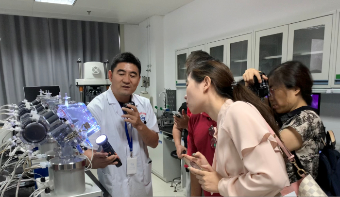 图为山东省医疗器械和药品包装检验研究院工作人员在检验室开放日活动中向公众介绍人工心脏瓣膜检验过程。