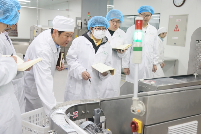 图为区域检查第五分局组织开展的药品生产安全隐患大排查大整治行动中，监管人员在一家企业查看生产关键环节数据。