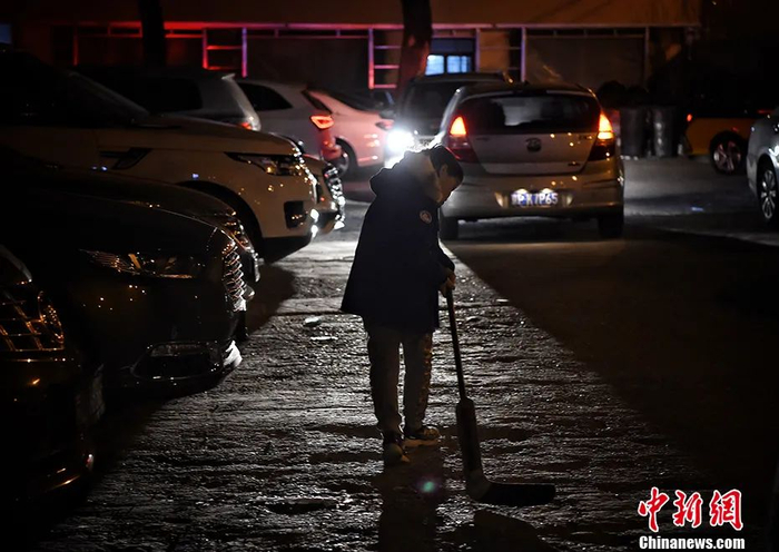 一个孩子在夜幕中边走路边挥舞着球杆。