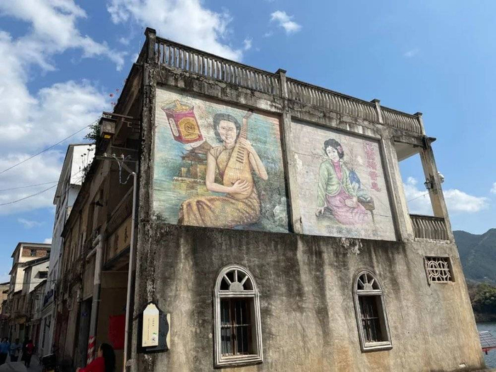 △古镇上的广告挂画风情十足。/作者供图