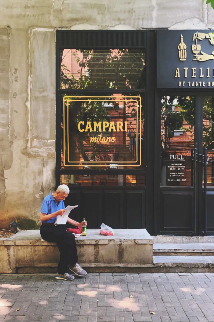 街边喝啤酒看报纸的老爷爷 @小芋