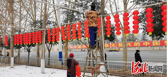 石家庄市园林工人正在悬挂灯笼。