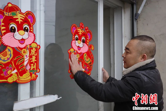 春节前夕，虎兵在家门口张贴虎年年画。王鹏