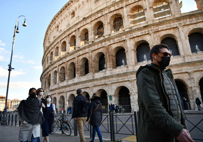 1月24日，人们佩戴口罩走过意大利罗马斗兽场。新华社记者金马梦妮摄