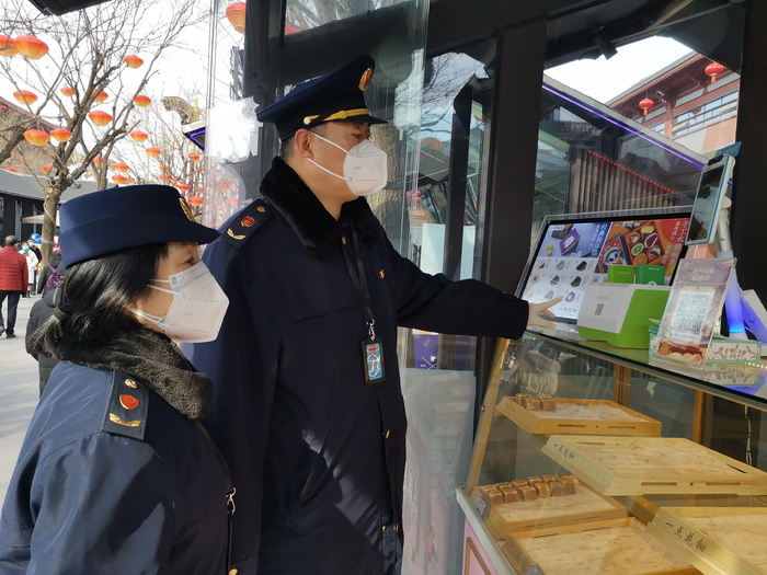 2月1日，大雁塔所所长曹一鸣和王雪梅在大唐不夜城步行街区检查市场。徐文智摄