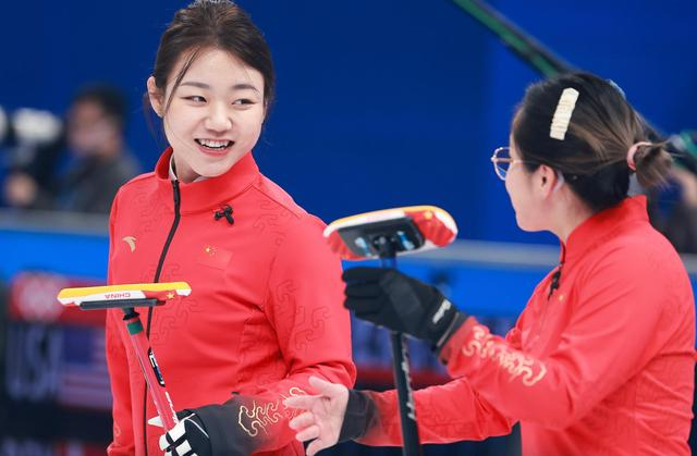 中国冰壶女队队长韩雨在比赛中和队友交流。图/新华社