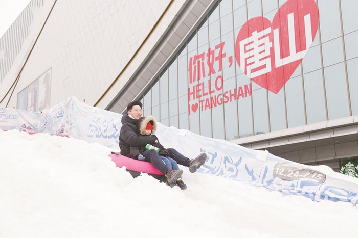 图为吾悦广场门前的冰雪乐园中，一对父子沉浸在坡道滑雪的乐趣中。 记者 刘大民 摄