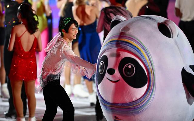 花滑选手与冰墩墩互动。图/新华社