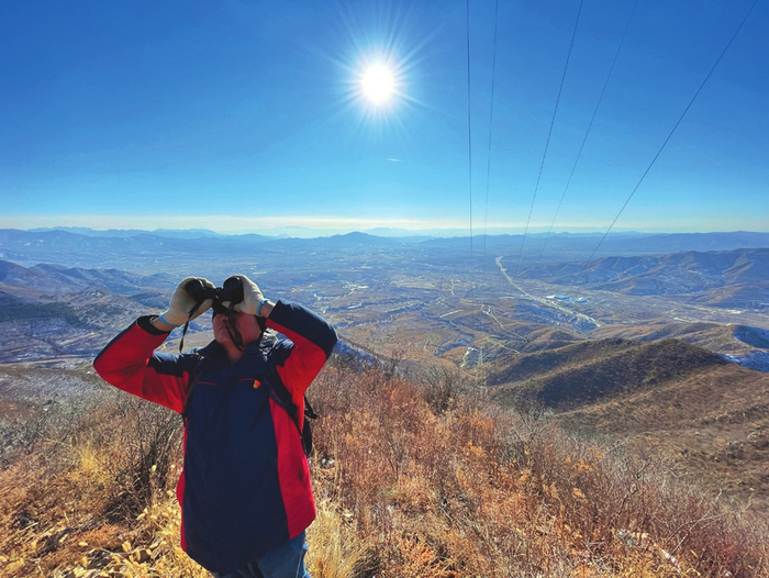 图为国网山西省电力公司输电应急抢险队队员在对保电线路进行精益化巡视。