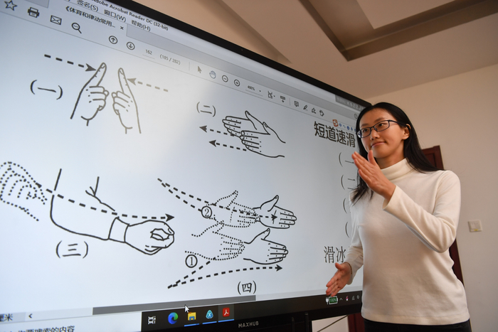 “国家通用手语系列丛书”主要负责编辑王一博展示手语版冰雪运动项目“短道速滑”。新京报记者 李木易 摄