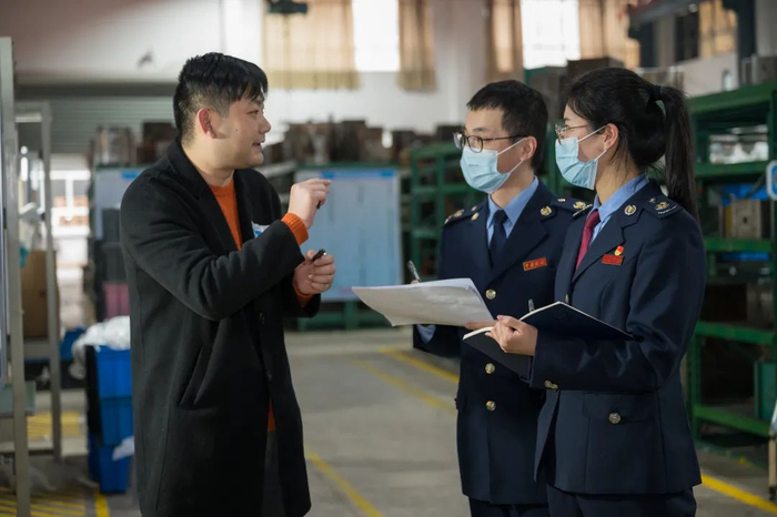 图为国家税务总局宁海县税务局干部到企业宣传税费优惠政策。葛菁楠/摄
