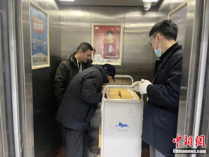 沈老俯身查看书籍的详细情况。徐珊珊 摄