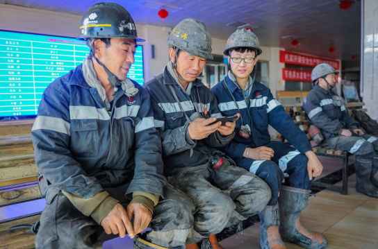 在国家能源集团宁夏煤业红柳煤矿，矿工在下井等候时，通过手机观看开幕会。高珊 摄