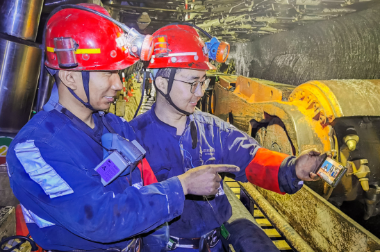 在国家能源集团神东煤炭锦界煤矿，离地面120米的煤矿生产工作面，矿工在工作休息空隙，通过防爆手机观看开幕会。李德春 摄
