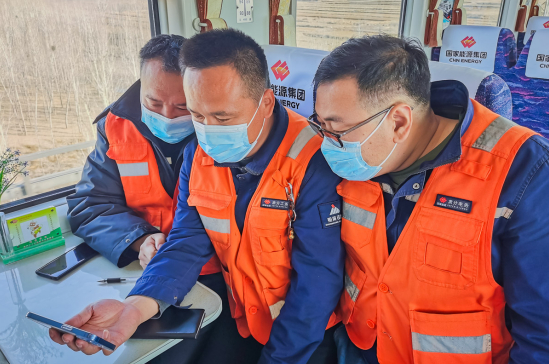 国家能源集团朔黄铁路公司员工利用巡检间隙，在铁路轨道巡检车上，用手机观看开幕会。张依萌 摄