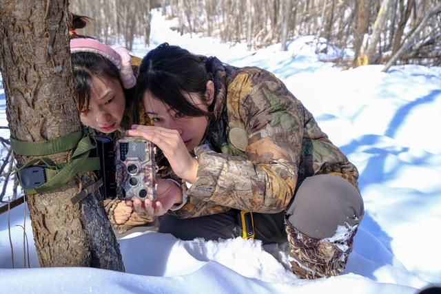 今年2月，白雪（左）和徐春梅（右）在维护远红外摄像机。受访者供图