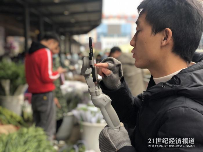 （在花市走播的花商 舒晓婷/摄）