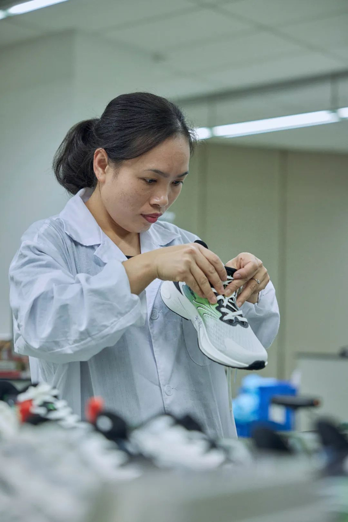 安踏员工正在手工检测一双鞋的质量（黄宇 摄）