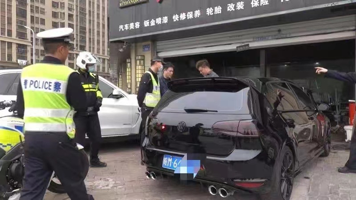 执法人员对机动车非法改装进行查处。