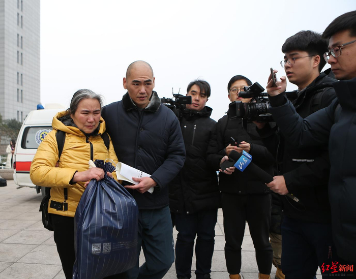 ▲张志超和母亲马玉萍走出法院
