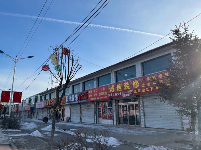 山西大同新荣区，一条街道上开了几家装饰、水暖建材店，刘学州的父亲丁双全也做这一行（李晓洁 摄）
