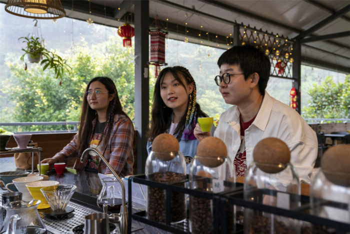 游客在云南普洱市思茅区小凹子咖啡庄园内品尝咖啡（2月22日摄）。新华社记者 陈欣波 摄