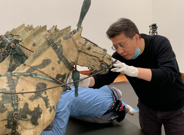 陕西省文物交流中心布展工作人员正在组装铜车马（主办方供图）