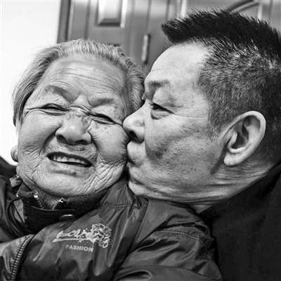     宁波市镇海区，家族宴会中，88岁的母亲被56岁的小儿子亲吻时的笑容。