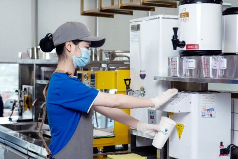 　　图为茶百道成都银石店的员工在为顾客调配饮品。