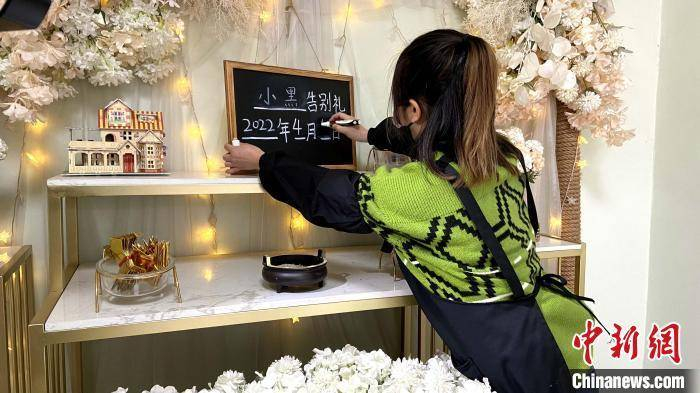 “90后”宠物殡葬师在小黑板上写上宠物名字。　孙婷婷 摄