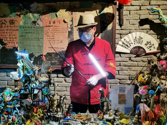 王府井百货“和平菓局”，“棕编张”正向游客展示棕编手艺。实习生 张晓悦 摄