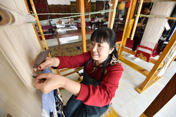 在河北省廊坊市文安县华盛宫毯坊，宫毯织造艺人正在织造宫毯。王晖摄