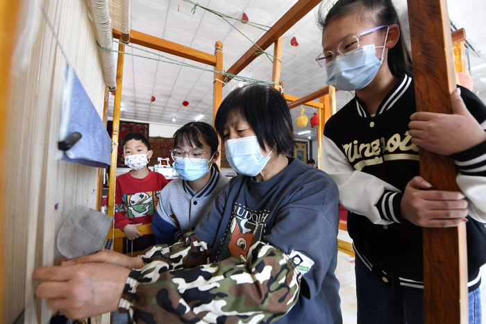 在河北省廊坊市文安县华盛宫毯坊，孩子们正在参观宫毯制作流程。王晖摄