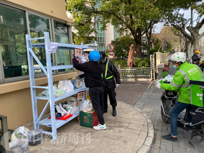 上海小区门卫处，正在派送的外卖小哥。摄影：《中国经济周刊》记者 宋杰
