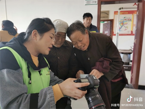 　　志愿者给老人看照片