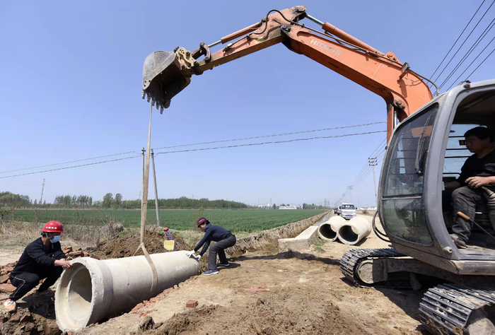 在河北省文安县兴隆宫镇小郭庄村水系连通工程现场，工人正在拆除阻水坝，铺设过水管道。高丹钰摄