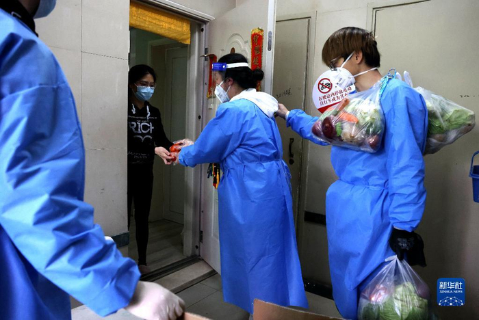 在上海市普陀区锦绿新城，社区志愿者为居民挨家挨户运送生活物资（4月11日摄）。新华社记者 陈飞 摄