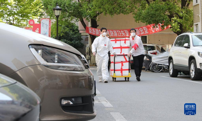 上海市闵行区七宝镇社区志愿者施忠良（左）与他的志愿者伙伴一起为居民派送生活物资（4月11日摄）。新华社记者 方喆 摄