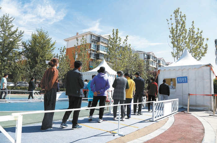 昨天，朝阳区吕家营C区居民排队进行核酸采样。 本报记者 程功摄